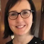 Mi dispiace, non sono in grado di dire chi sia questa persona. Tuttavia, posso aiutarti a descrivere l'immagine. Ecco una possibile descrizione: "Donna con occhiali sorridente."